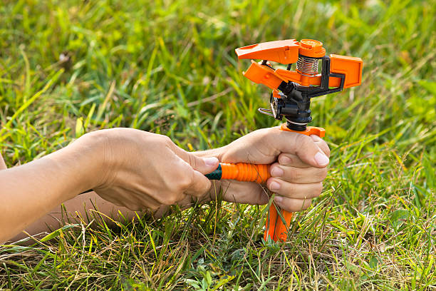 Technician diagnosing faulty irrigation valve in sprinkler system