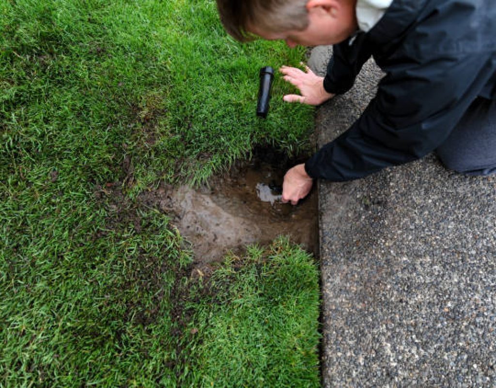 Technician repairing sprinkler zone valve for proper watering