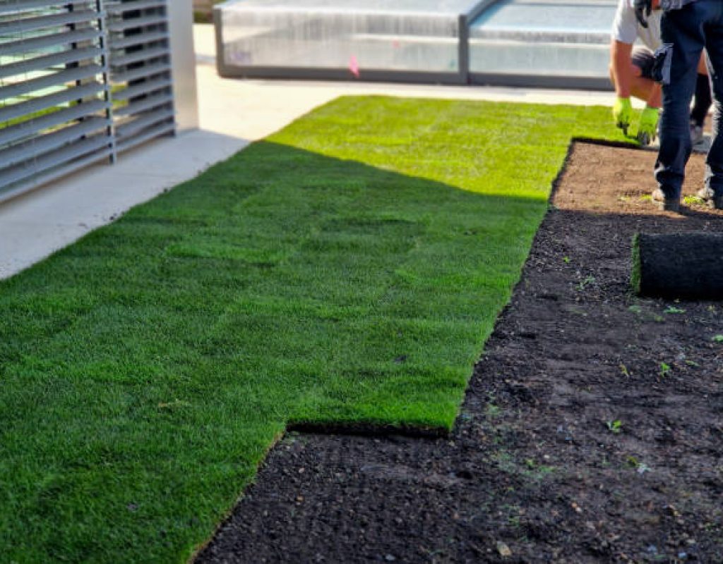 Fresh green artificial turf being laid by East Bay landscaping experts Miles Creek Irrigation