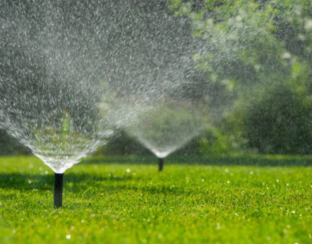 Lawn irrigation technician repairing faulty sprinkler controller
