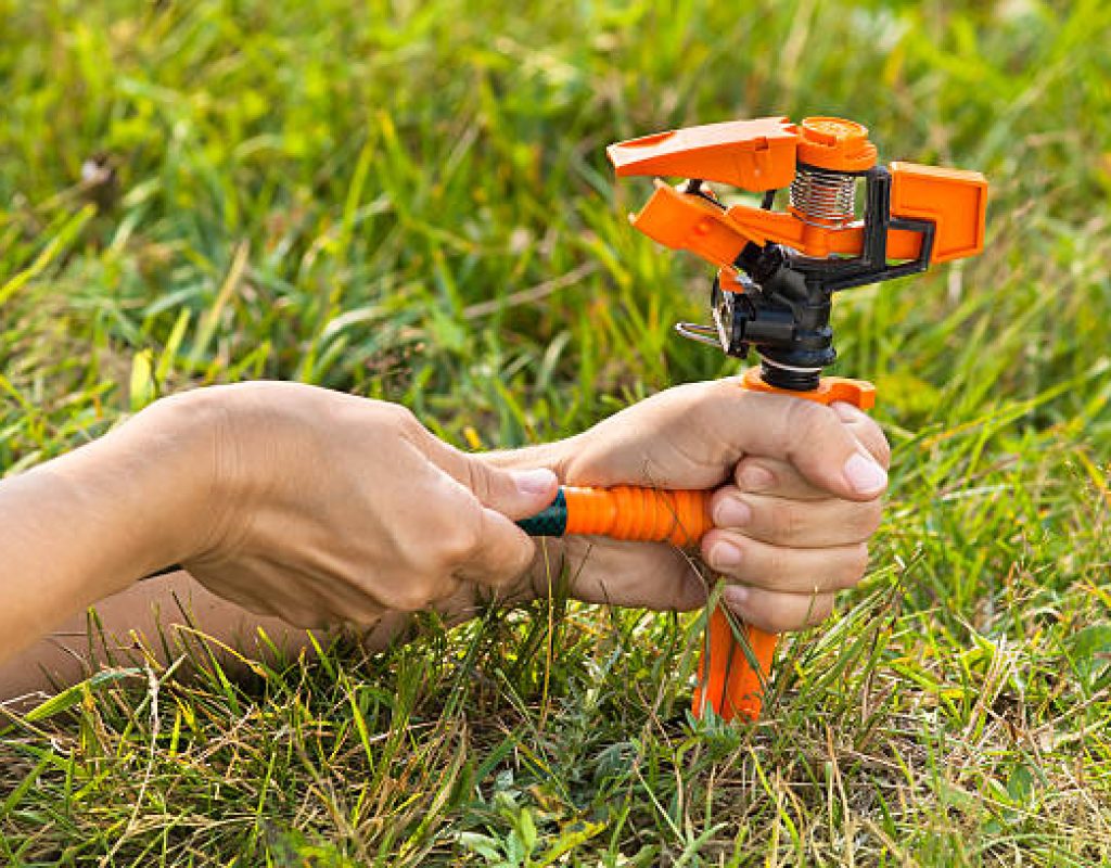 Technician diagnosing faulty irrigation valve in sprinkler system