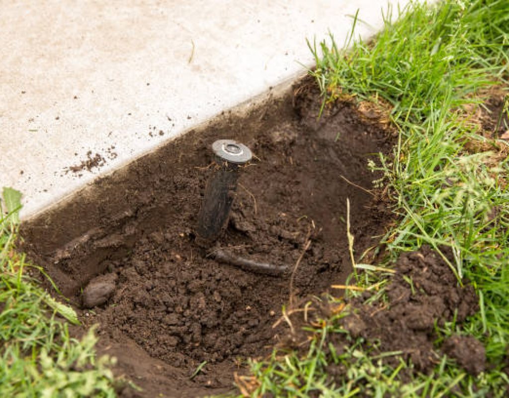 Professional adjusting irrigation timer during sprinkler repair